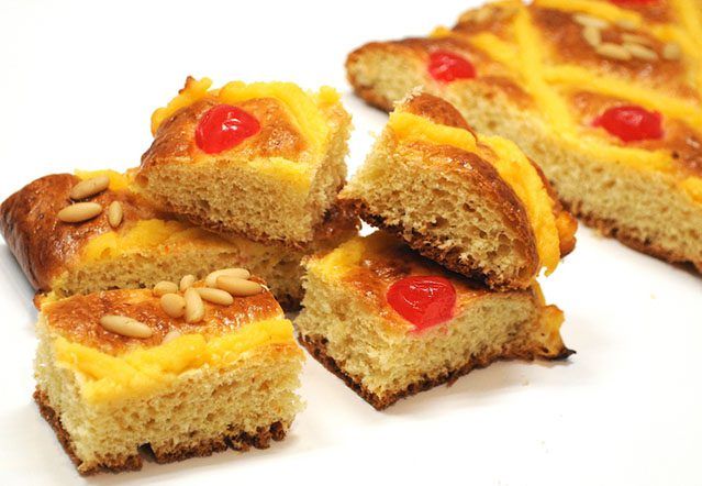 Auténtica Coca de San Juan Artesanal - Angela Moreno Repostería, pasteles personalizados en Barcelona. Coca de San Juan tradicional con frutas confitadas y piñones, postre festivo en Barcelona. Angela Moreno Repostería, pasteles personalizados en Barcelona.